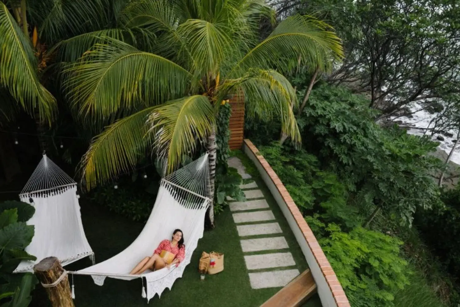 Woman relaxing in a hammock under palm trees with ocean views, enjoying a peaceful tropical escape—one of the many relaxing things to do in Nicaragua.