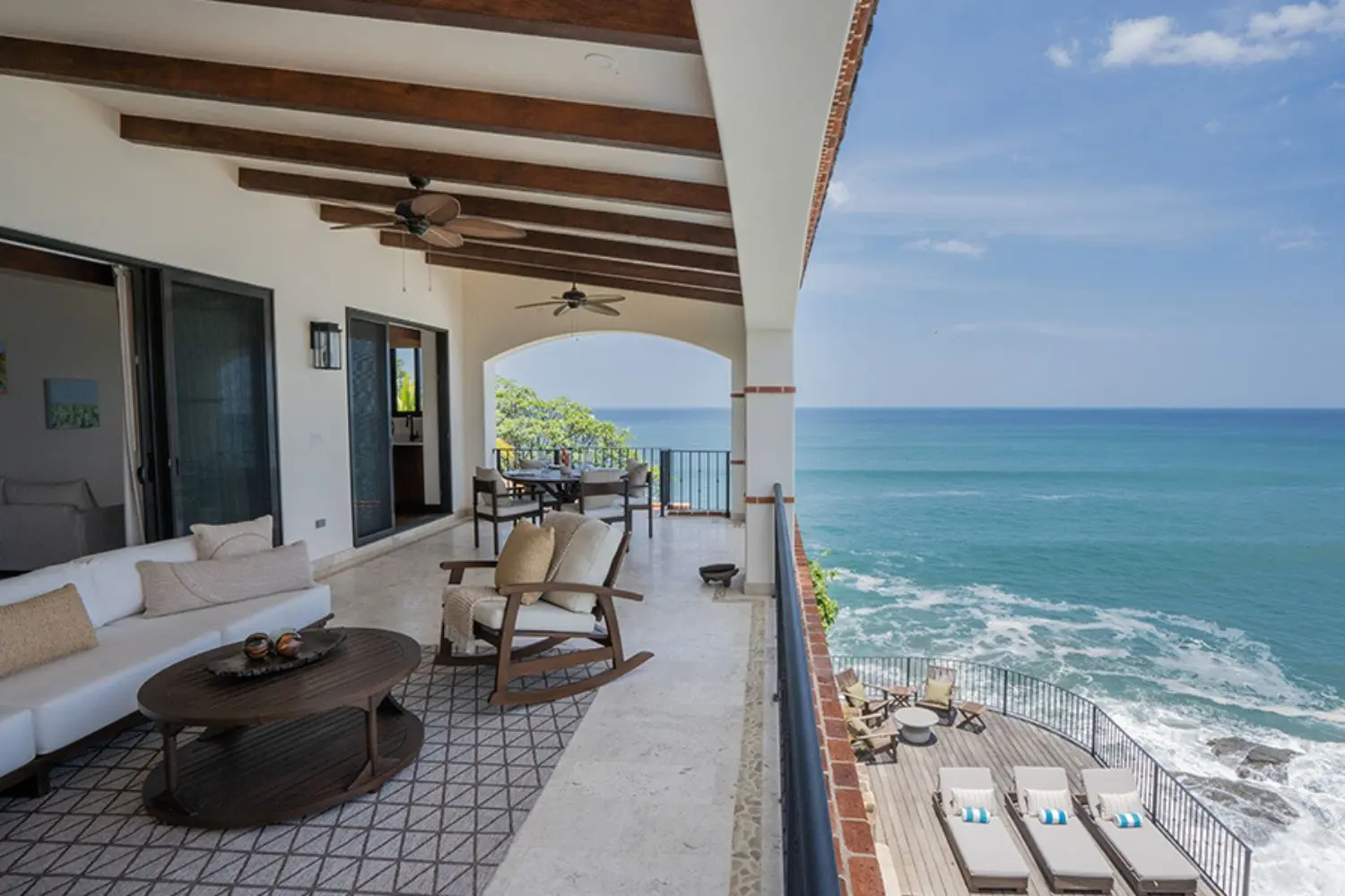 Expansive oceanview terrace at Villa Cielo G10 in Rancho Santana, Nicaragua, featuring elegant outdoor lounge furniture, ceiling fans, and private sun deck above the Pacific—showcasing high-end coastal living in the Costa Rica vs Nicaragua luxury beach destination comparison.